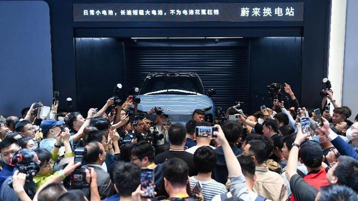4月25日，在2024北京国际车展上，一群参观者在蔚来汽车展台参观电动汽车换电站演示。新华社记者 鞠焕宗 摄