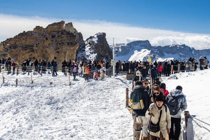 游客在长白山天池参观游览（2024年3月26日摄）。新华社记者 许畅 摄