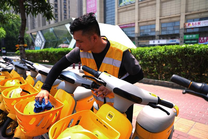 黄世用擦拭车辆，让市民用得舒心 本报记者李洋 摄