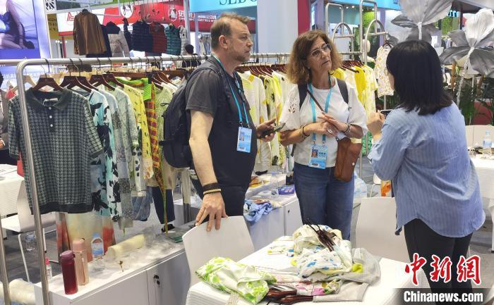 5月3日，广交会境外采购商与中国企业设计师围在一起商讨衣服的用料和设计。中新社记者 　蔡敏婕 　摄