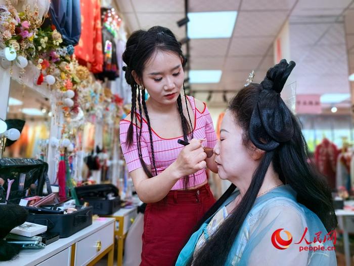 汉服妆造师李新敏正在给顾客化妆。人民网记者王佩摄