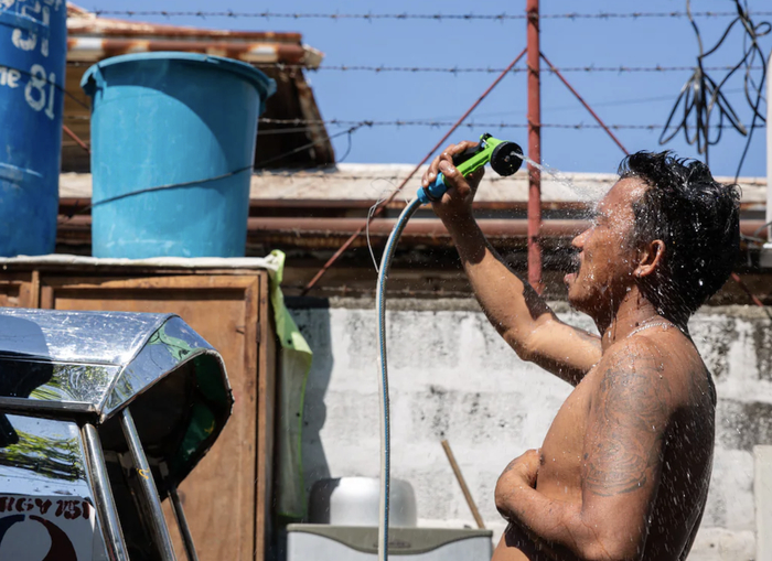 ▲4月28日，菲律宾马尼拉，一男子在浇水降温