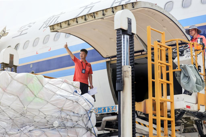 　　2024年“五一”期间，广州白云机场，南航装卸员侯华伟与同事一起装载航班行李和货物。（南航供图）