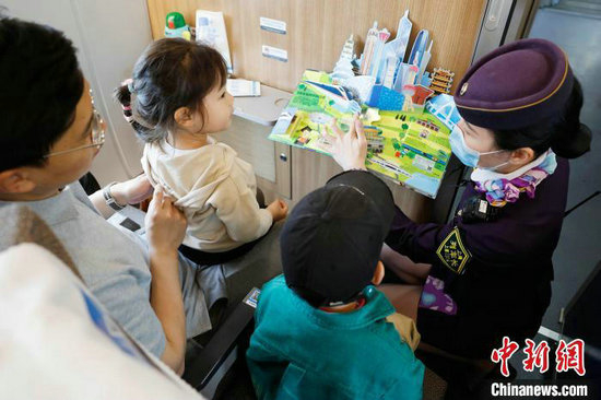 封盛给孩子介绍“流动书屋”内的书籍。中新网记者 殷立勤 摄