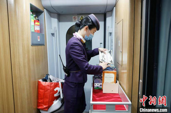 封盛在为列车上的“流动书屋”摆放书籍。中新网记者 殷立勤 摄