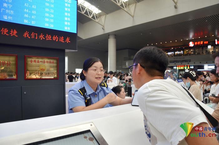 “最美铁路人”李军在“红土情”服务台解答旅客问询。刘慕 摄