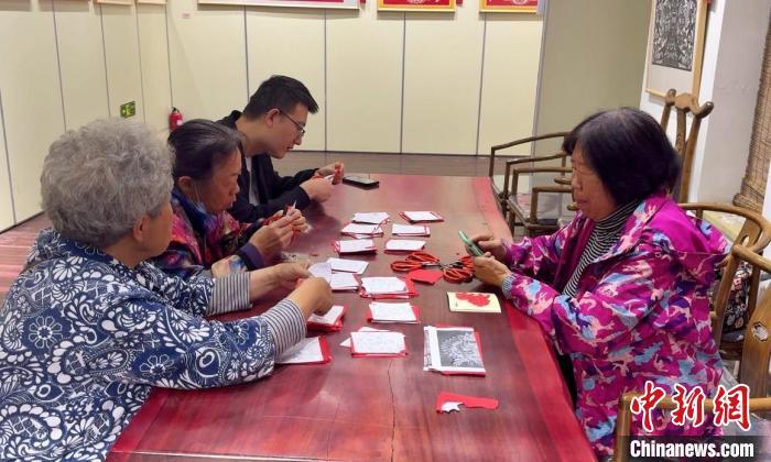 游客现场体验剪纸，感受中华传统文化的魅力。杨静摄