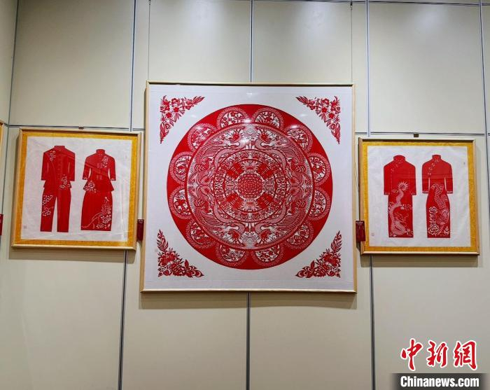  现场展出的盘合作品和《婚俗服饰》系列剪纸作品。杨静摄