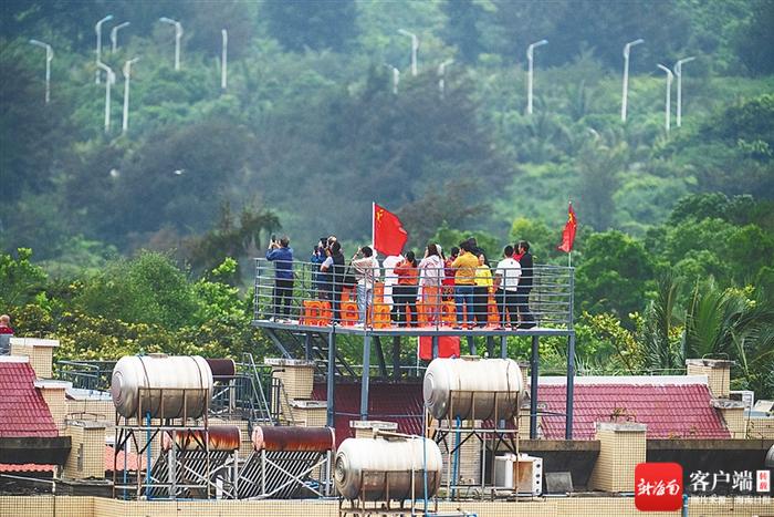 游客在文昌龙楼镇一居民楼顶观礼火箭发射。海南日报记者袁琛 摄