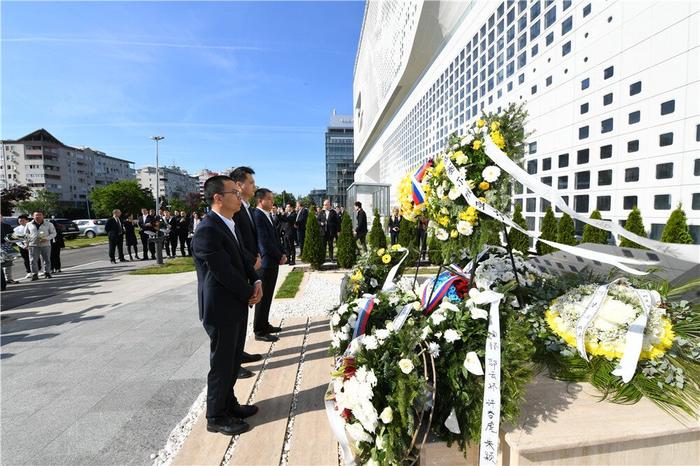 在塞尔维亚贝尔格莱德，中资企业代表在中国驻南斯拉夫联盟大使馆旧址前的烈士纪念碑前肃立。新华社记者 任鹏飞 摄