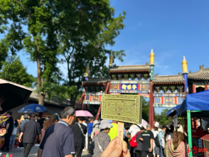 ▲游客在荣国府手拿文创雪糕拍照打卡