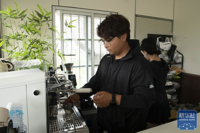5月7日，潜山市南北咖啡馆主理人胡瑞在制作咖啡。新华社记者 傅天 摄
