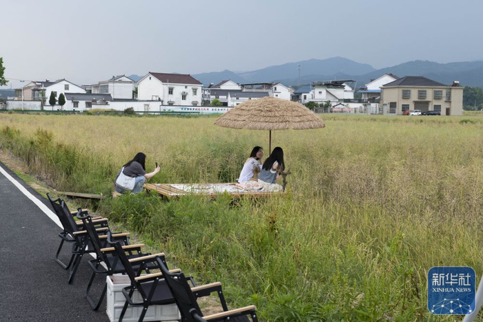 5月7日，顾客在潜山市南北咖啡馆室外区域赏景拍照。新华社记者 傅天 摄
