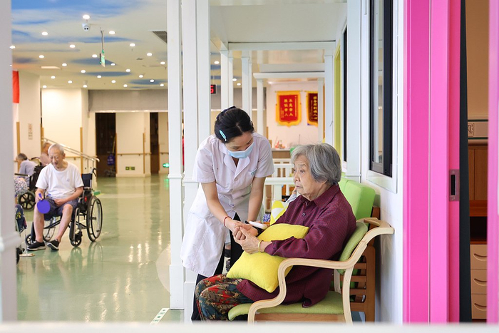 2023年7月18日，重庆市沙坪坝区小龙坎街道社区养老服务中心，护士为老人测血压。视觉中国 资料图