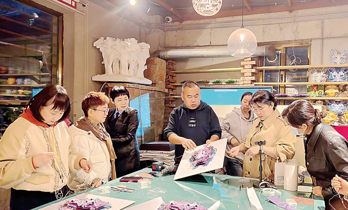 职工在“夜校”学习剪纸技艺。袁文瑜 摄