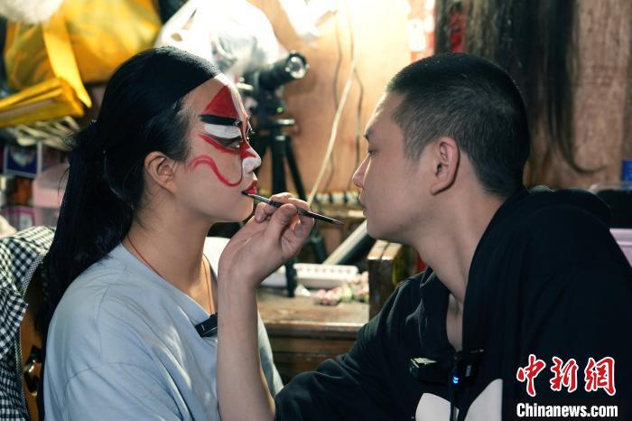 4月25日，四川成都，川剧演员为洪婉晴(左)化妆。安源 摄