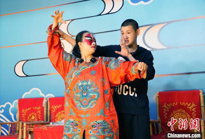 4月25日，四川成都，洪婉晴(左)在川剧演员指导下学习川剧。安源 摄
