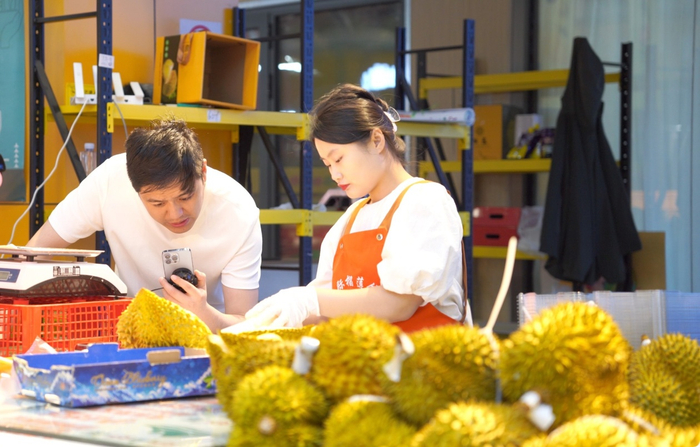 榴莲商家正在通过手机直播销售榴莲。人民网记者 申佳平摄