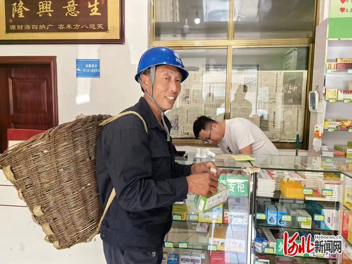 邢海明在药店帮村民们买药。（黄雨晗/摄）