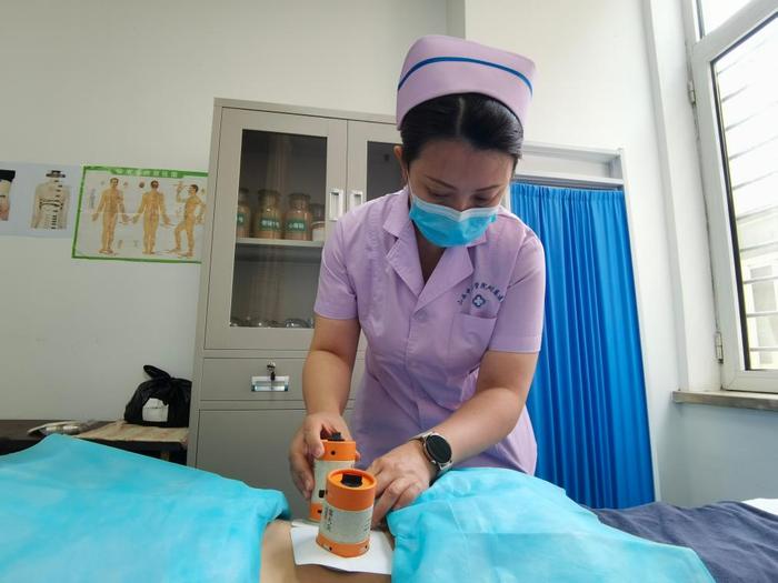　　在中国中医科学院西苑医院山西医院中医护理门诊，谭娟为患者做艾灸护理。（受访者供图）