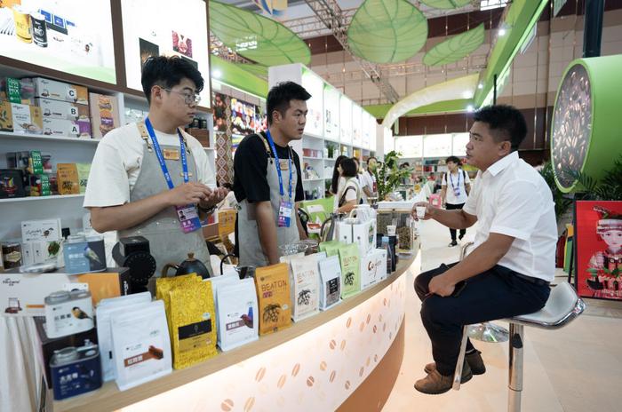 来自云南保山的参展商在第七届中国—南亚博览会上向参观者介绍咖啡产品（2023年8月16日摄）。新华社记者 陈欣波 摄