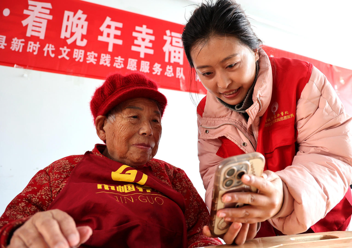 ▲山东滨州一家养老机构内，志愿者教老年人使用智能手机。据视觉中国