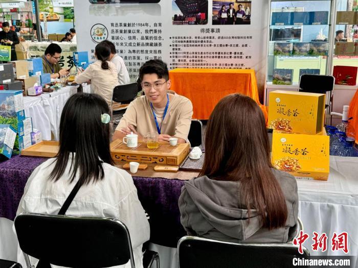 王柏欣正在为大陆青年茶商介绍台湾高山茶。叶智成/摄
