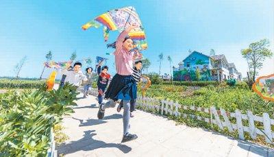 孩子们在江苏省泗洪县石集乡柳山新居“小菜园”放风筝。张连华 摄（人民视觉）