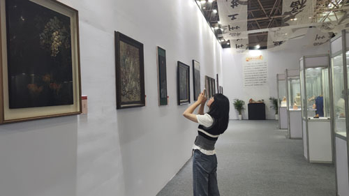 　　图为观众正在欣赏福州软木画作品。