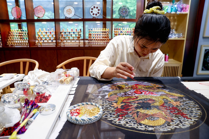 洪利正在绣绷上飞针走线，丝线在她灵巧的手中变成栩栩如生的图案。 张畅 摄/中新社