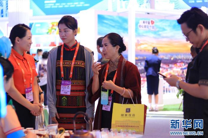 5月10日，中国品牌博览会现场，陈孟秋（左）在为参展者讲解利川红茶特点。