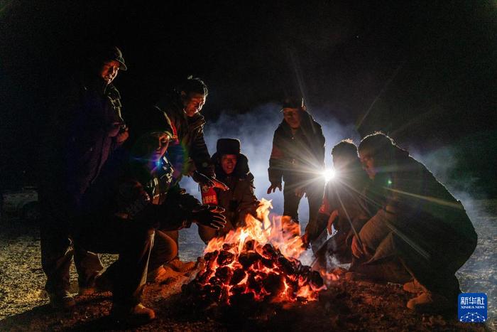 野生动物专业管护队员在宿营地里烤火，燃料是野牦牛的粪便（5月10日摄）。新华社记者 丁增尼达 摄