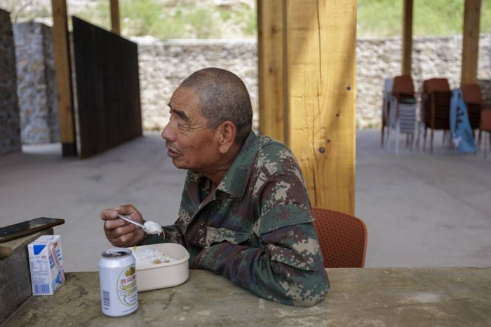 5月14日，京西门头沟雁翅镇苇子水村，古梯田景观台，66岁的村民高丰品吃着自带的午饭。新京报记者 王子诚 摄