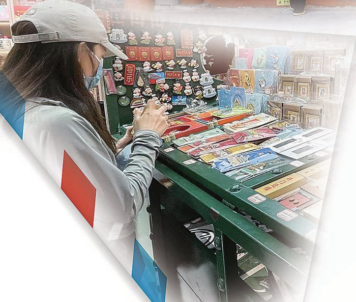 　　新国潮主题邮局内，顾客在百年邮车复制品所搭载的文创品展示台前挑选产品。本报记者 李洋摄