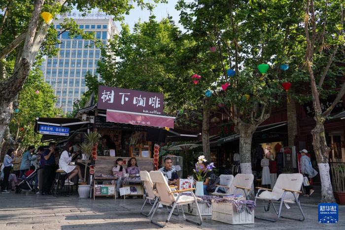 　　人们在甬道街上休闲游览（4月25日摄）。