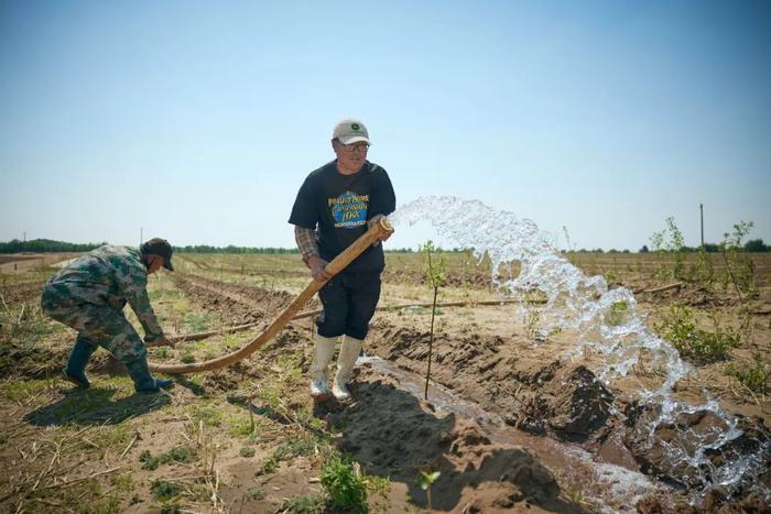  5月初正是内蒙古春耕的忙碌时节，农民们忙着在地里给新种的幼林浇水