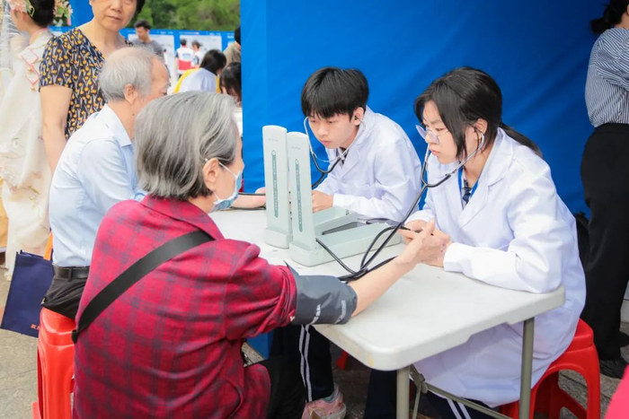 职校的医学生给现场市民测量血压。