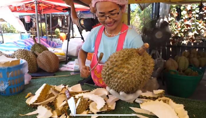 泰国街头摊贩正在挑选榴莲（图源自B站UP主吃吃喽视频截图）