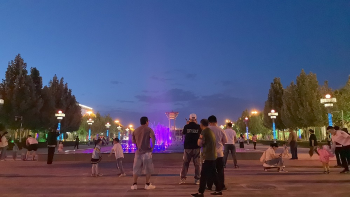 傍晚，市民们聚集在广场上看喷泉。胡杨网 李雨浪 摄