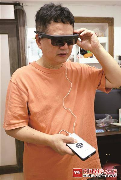 ▲陶进正在试用导盲眼镜。记者 何定坚 摄