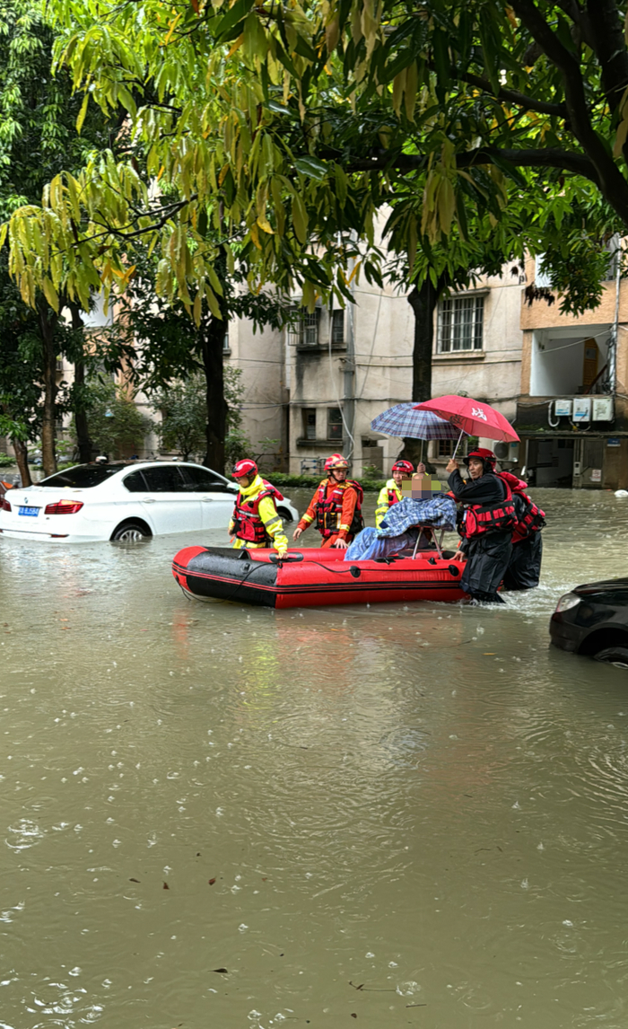 救援人员将行动不便的老人转移到安全区域。邹财麟 摄