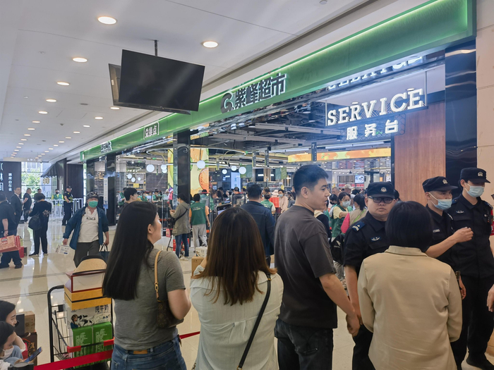 5月17日中午，未能进入紫峰超市的消费者正在询问情况。薛晶晶/摄