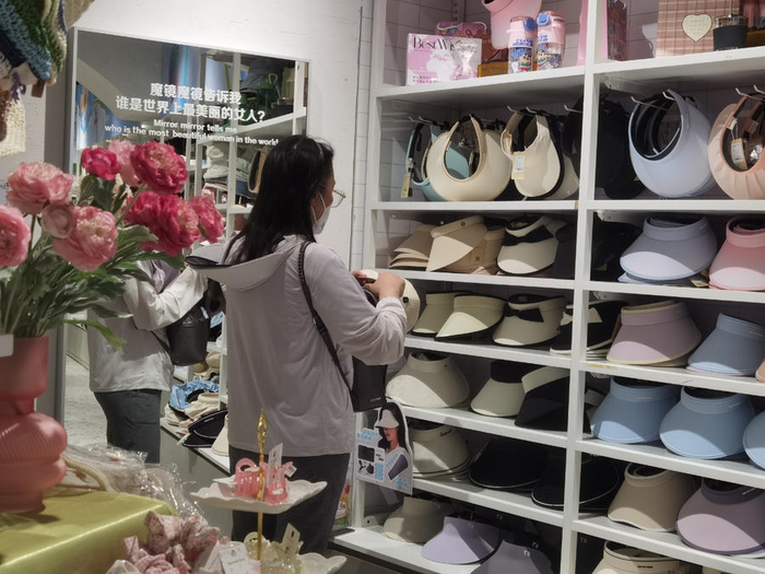 消费者在挑选防晒帽。