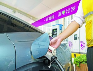 　　▲   　　5月19日，在位于深圳巴士集团深康充电站内的超充站，工作人员为一辆新能源汽车插枪充电。
