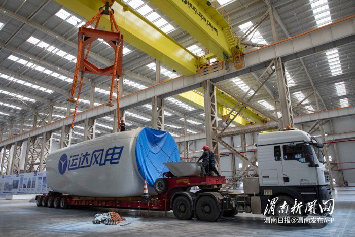 工人在风电装配“双碳”产业示范园项目主机厂房生产车间吊装风电机组