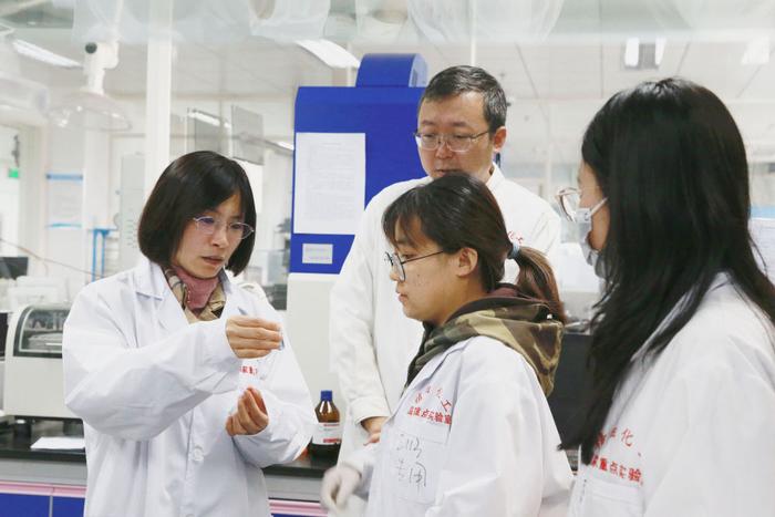大连理工大学化工学院樊江莉（左）教授与同事及学生查看实验结果（2021年11月摄）。新华社发