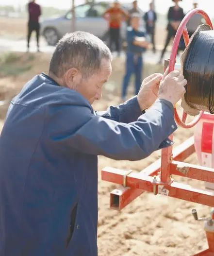 榆林市榆阳区古塔镇罗硷村村民借助机械搭设滴灌水管。采访对象供图