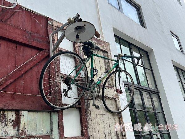 图说：店门口的墙上挂着古旧的“叔叔”自行车