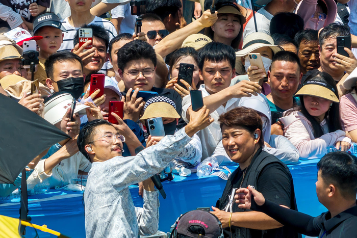 ▲5月18日，山东省菏泽市国花博览园，网红郭有才直播时演唱《诺言》等歌曲引众人围观 图据视觉中国