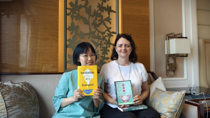 扶霞（右）与译者何雨珈分别拿着《君幸食》中、英文版